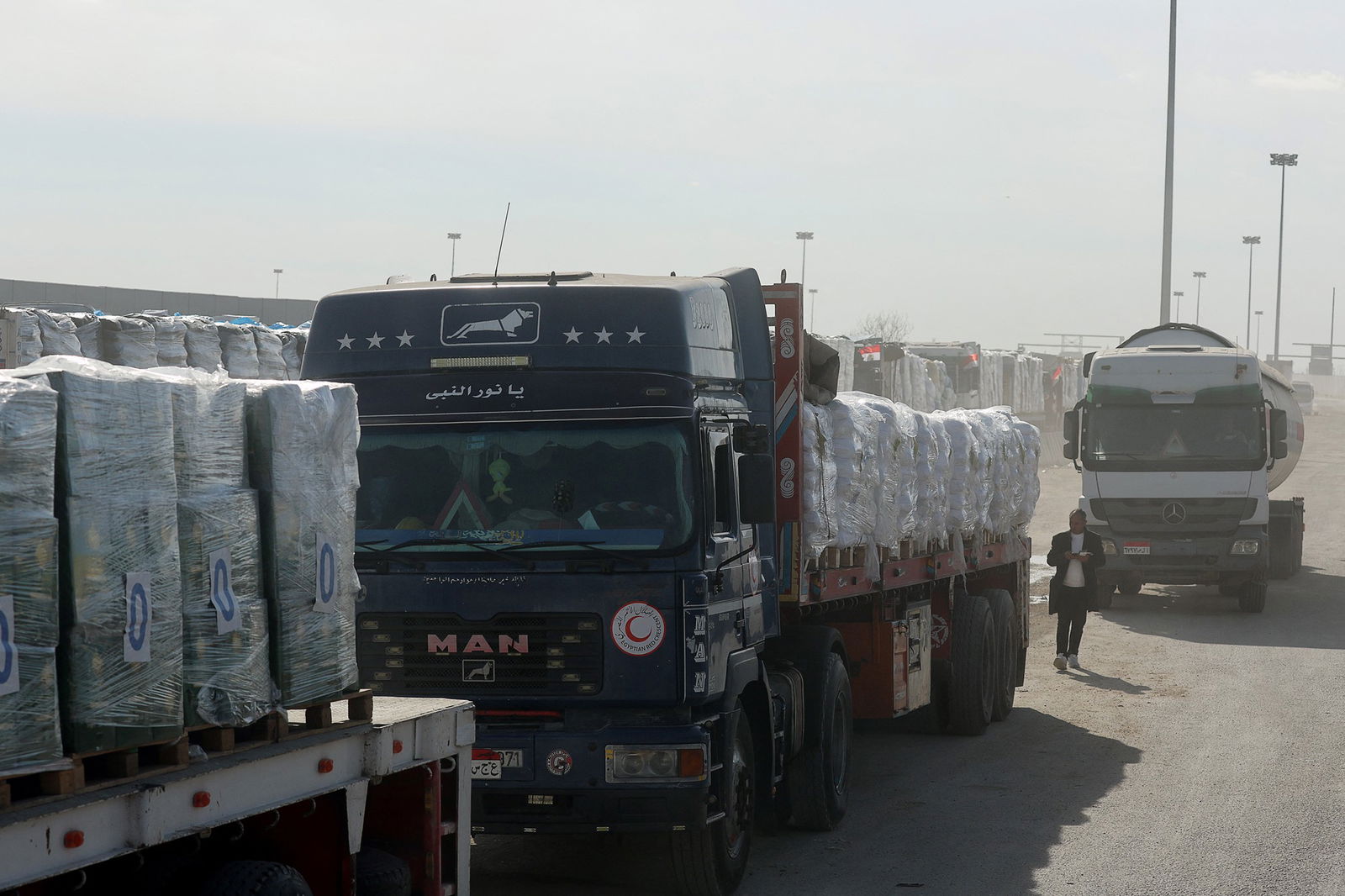 A line up of aid trucks entering Gaza carrying pallets of food and supplies.