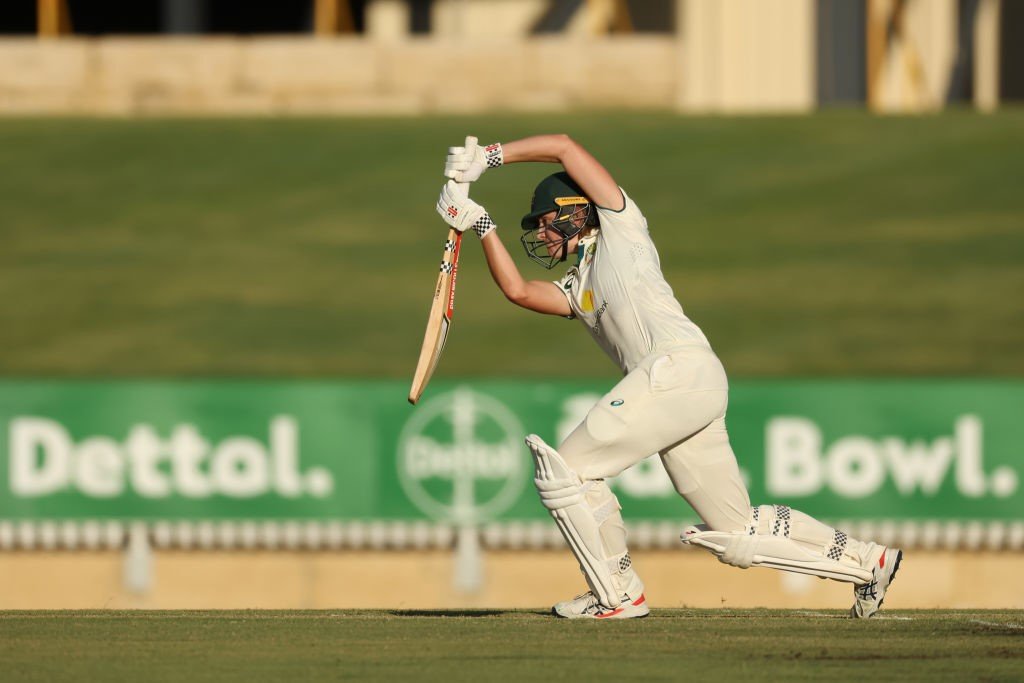 Australia batter Annabel Sutherland seen from side-on playing a straight drive.