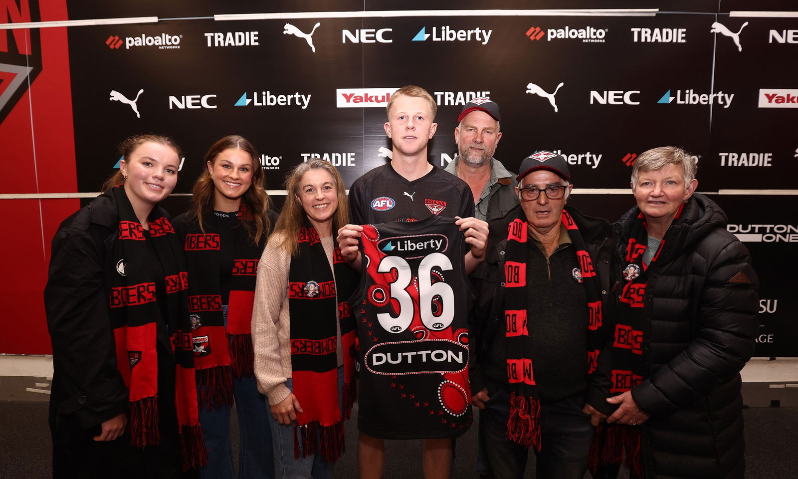 Angus Clarke with his family of the Bombers is presented his jumper by his dad for his debut game during the 2025 AFL Round 11 match between the Essendon Bombers and the Richmond Tigers at the Melbourne Cricket Ground on May 23, 2025 in Melbourne, Australia.