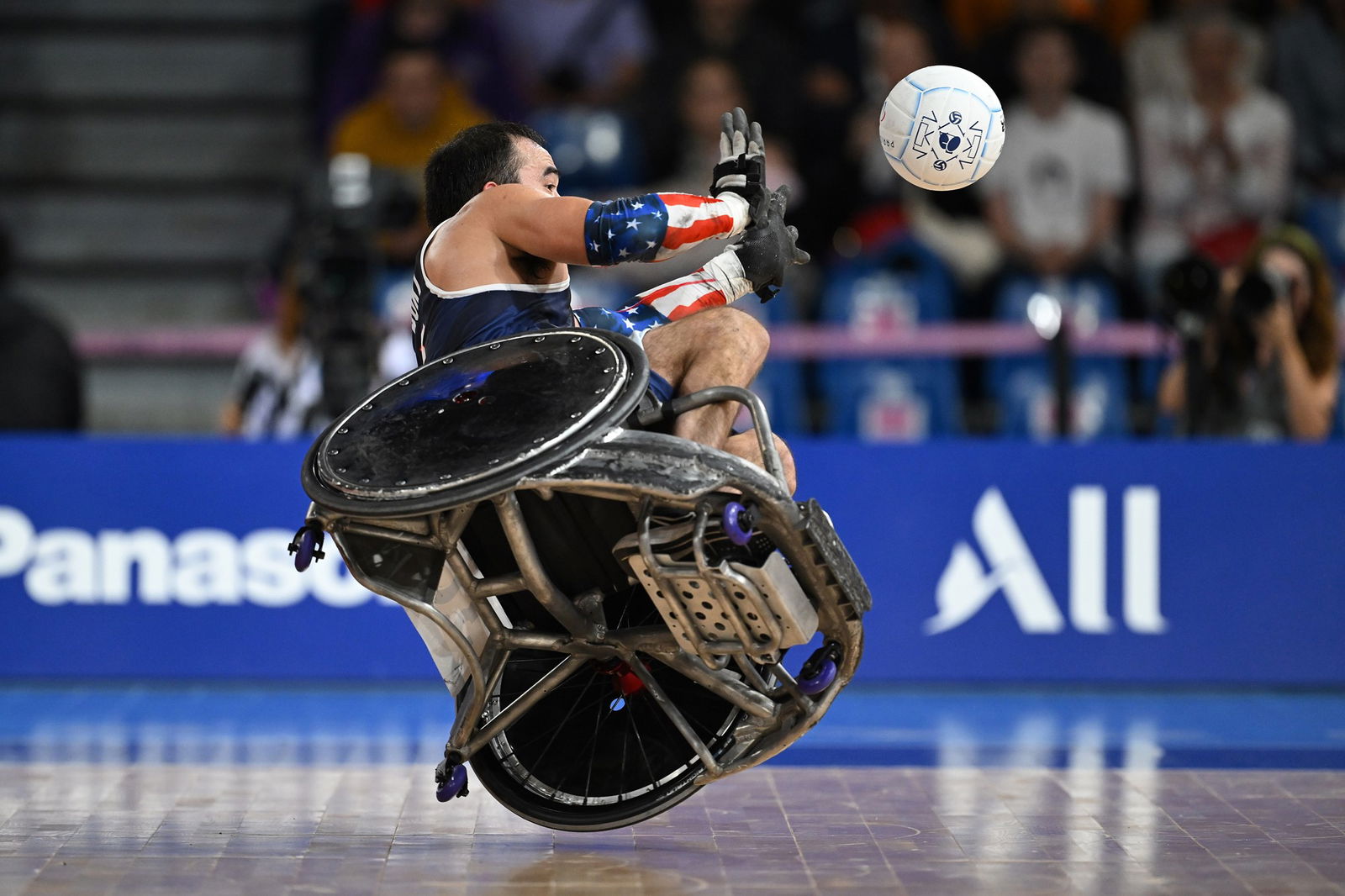 Chuck Aoki of the United States falls after passing in a wheelchair rugby game in Paris.