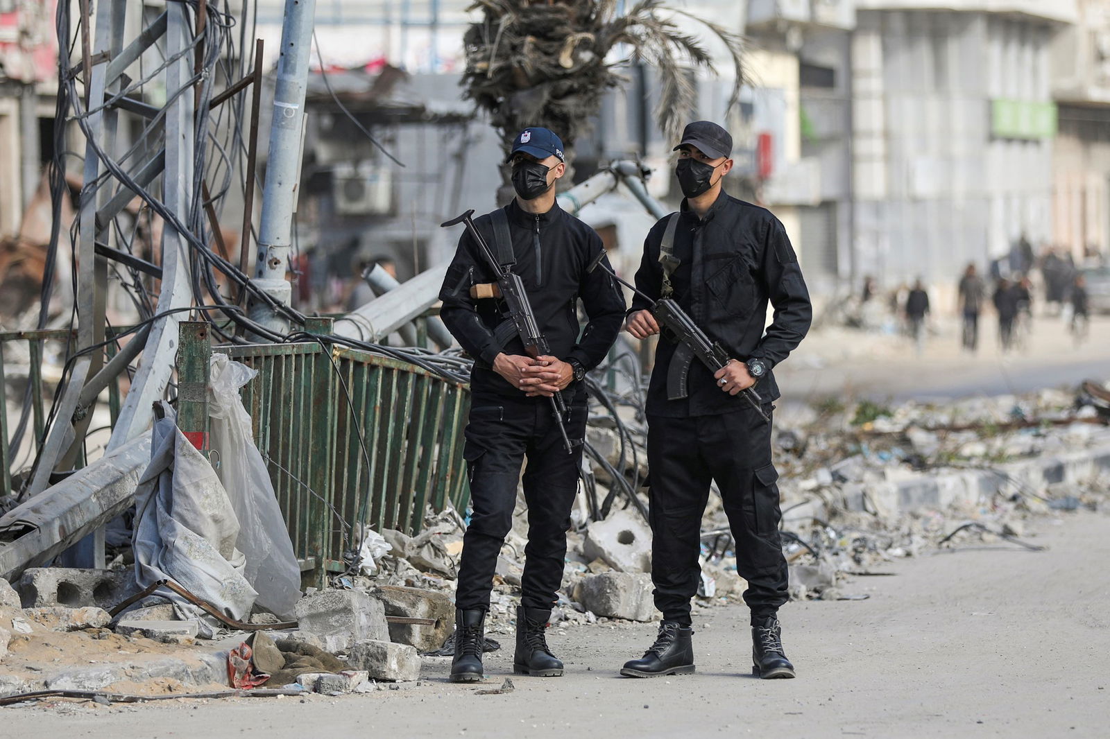 Two men dressed in black holding guns. 