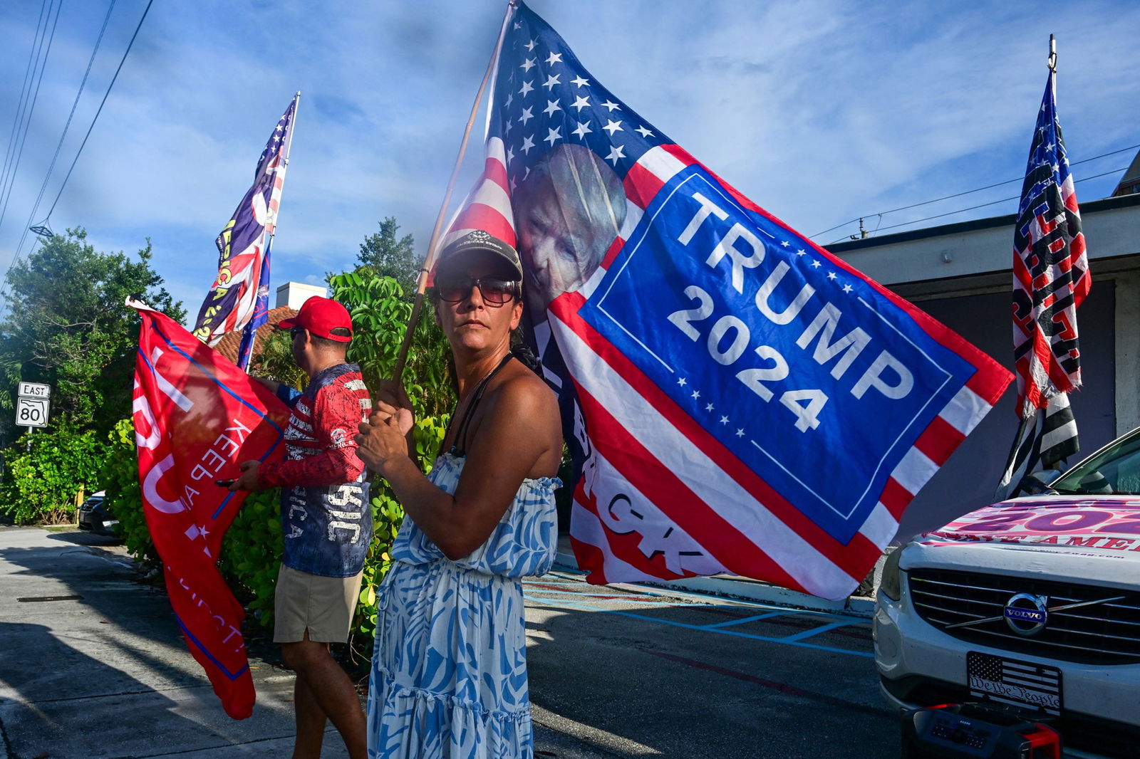 Trump supporters wave flags outside of his home