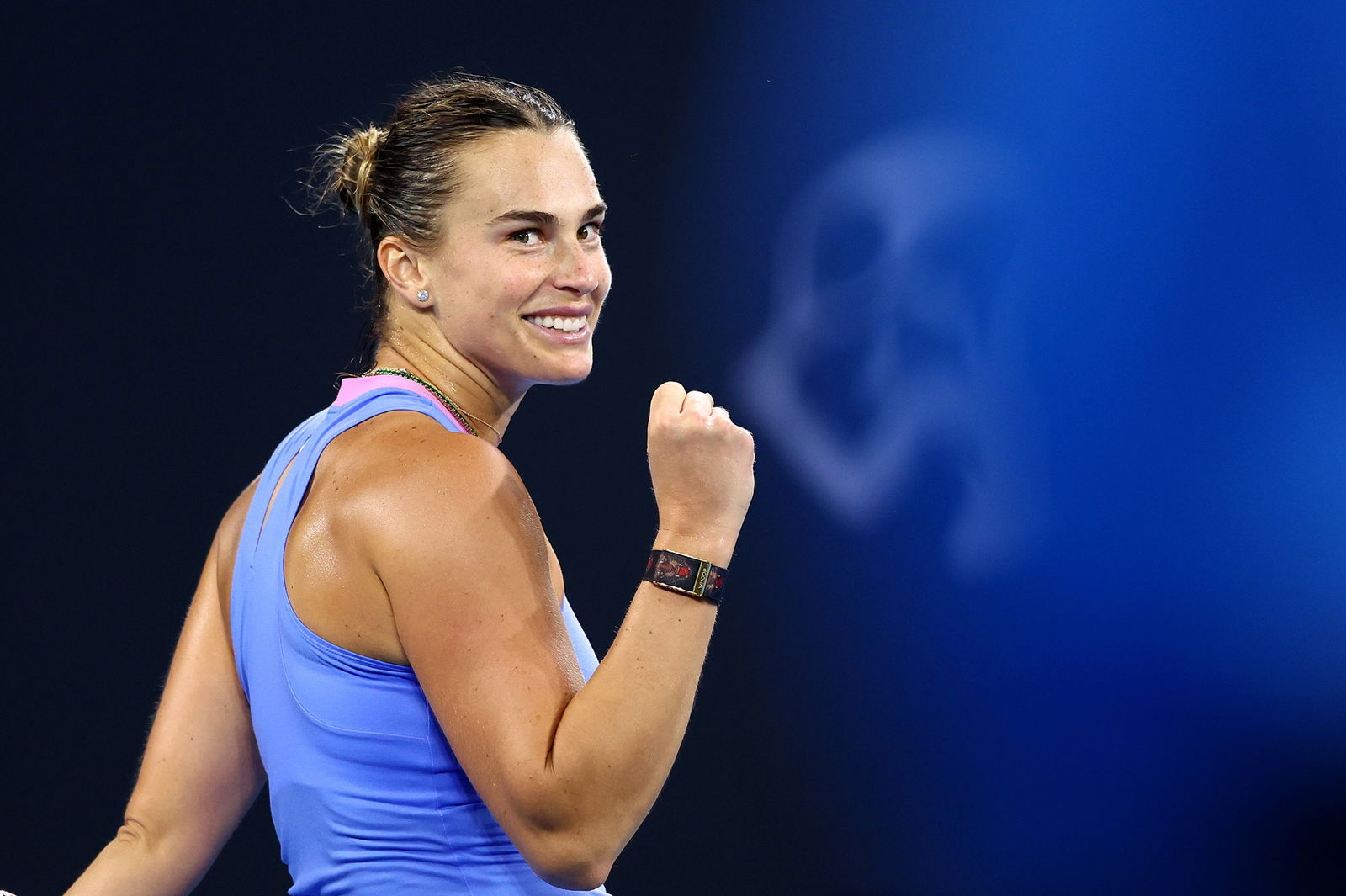 Aryna Sabalenka smiles and clenches her fist.