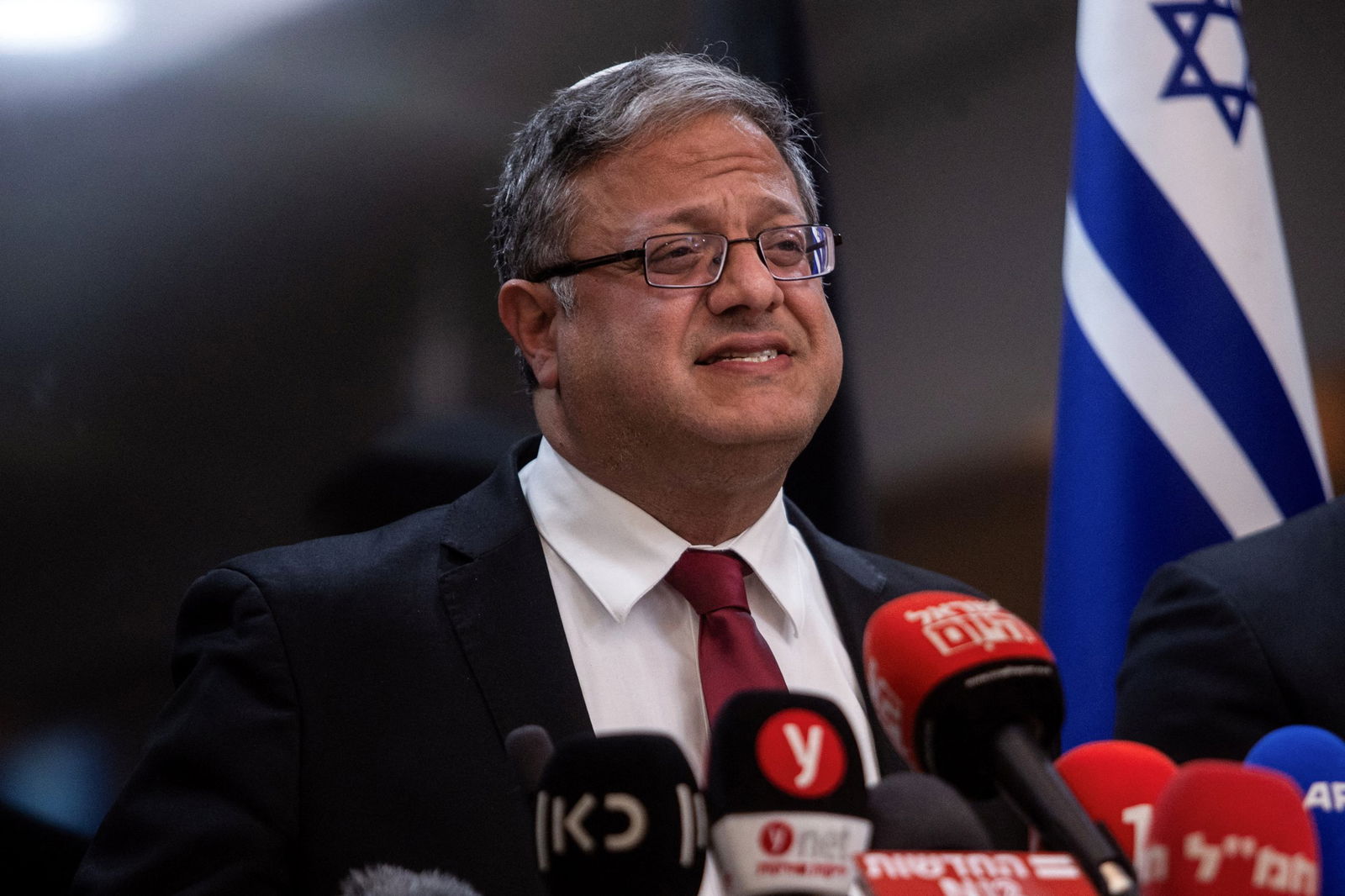 Ben-Gvir gives a press conference with an Israeli flag.