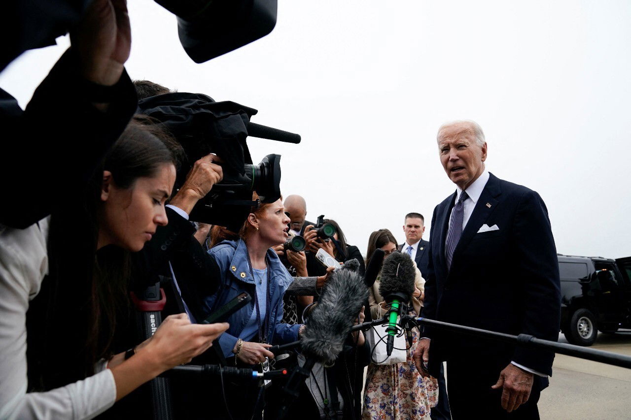 A man in a suit speaks to a large group of people.