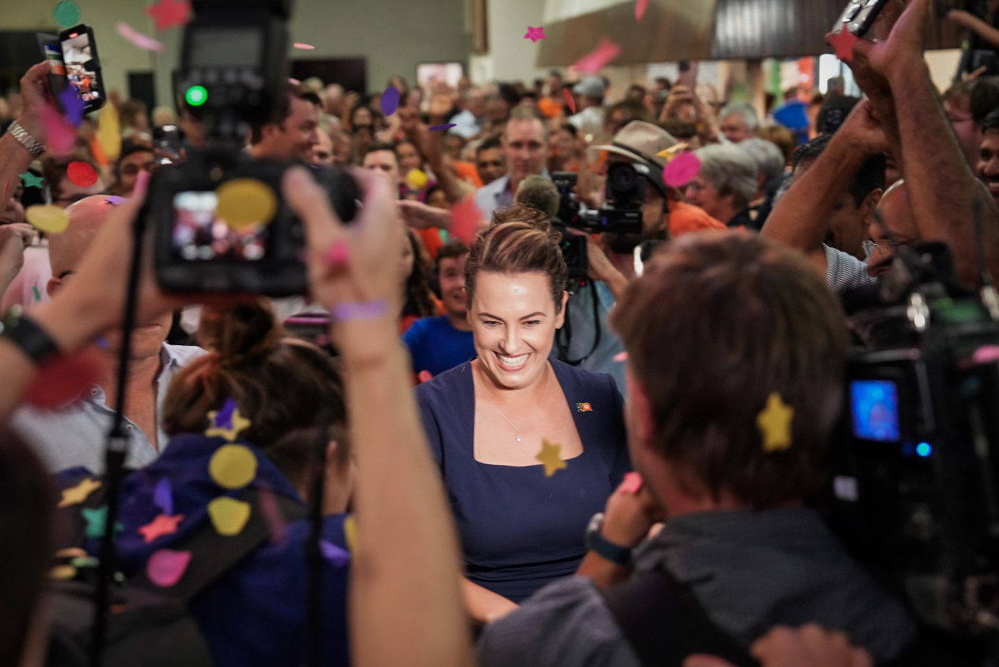 a female politician surrounded by crowds of people surrounded by confetti