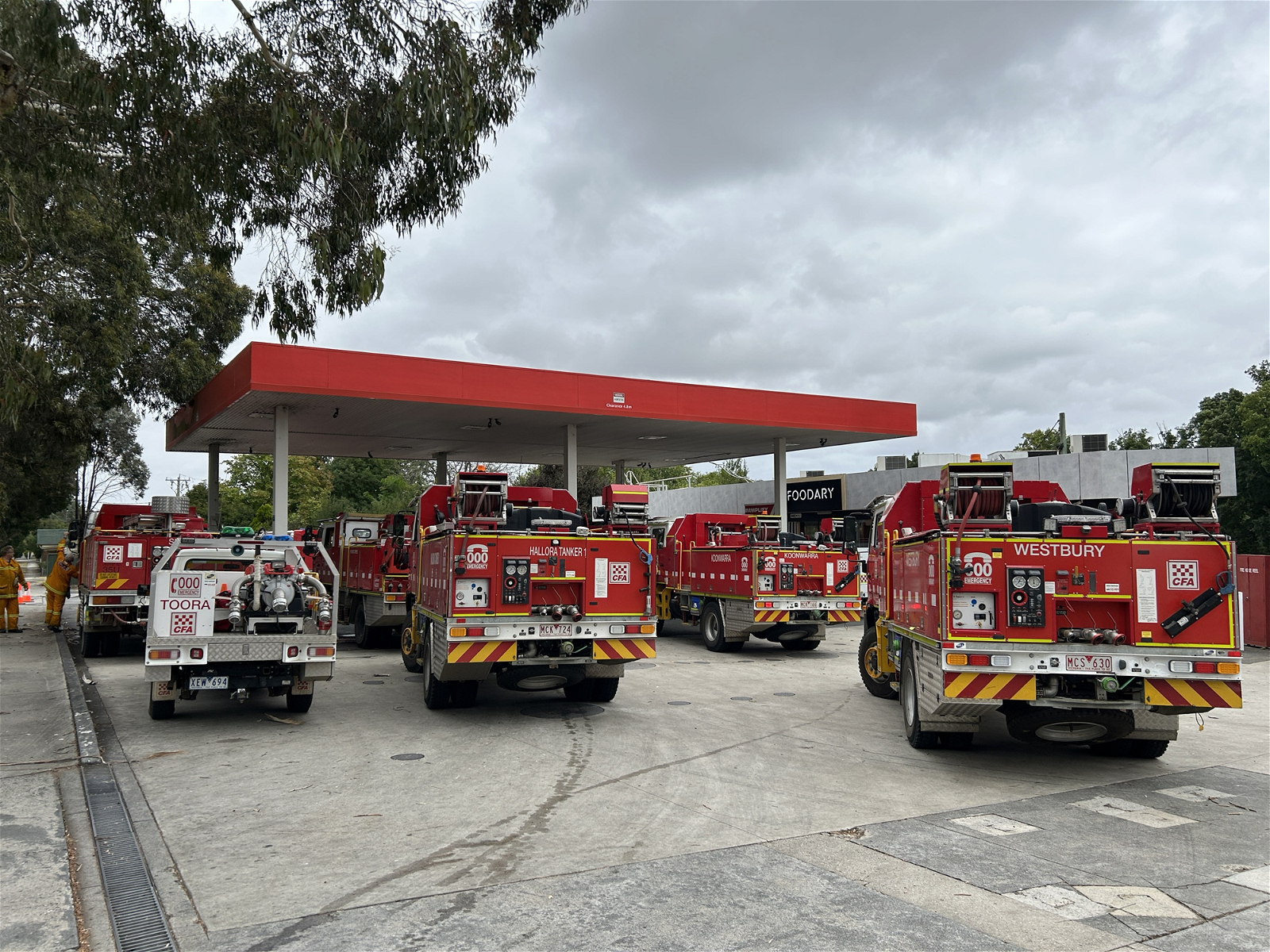 Several fire trucks at a petrol station.