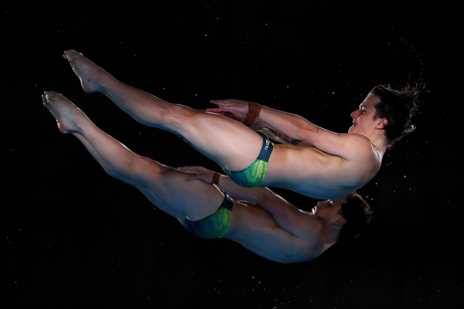 Two men warm up before a synchronised diving competition
