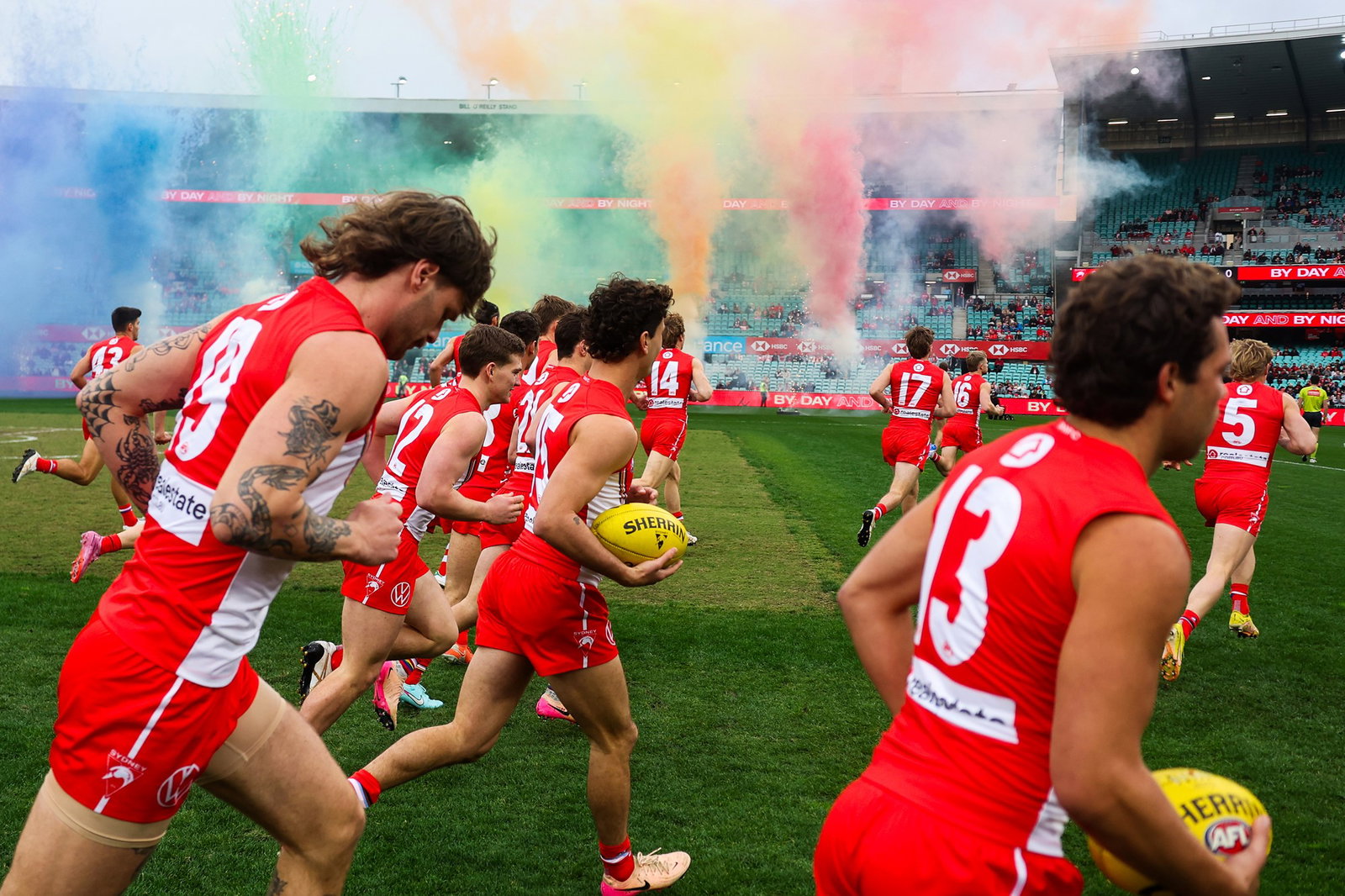Swans players run out in their pride jumper ahead of the clash against the Bombers.
