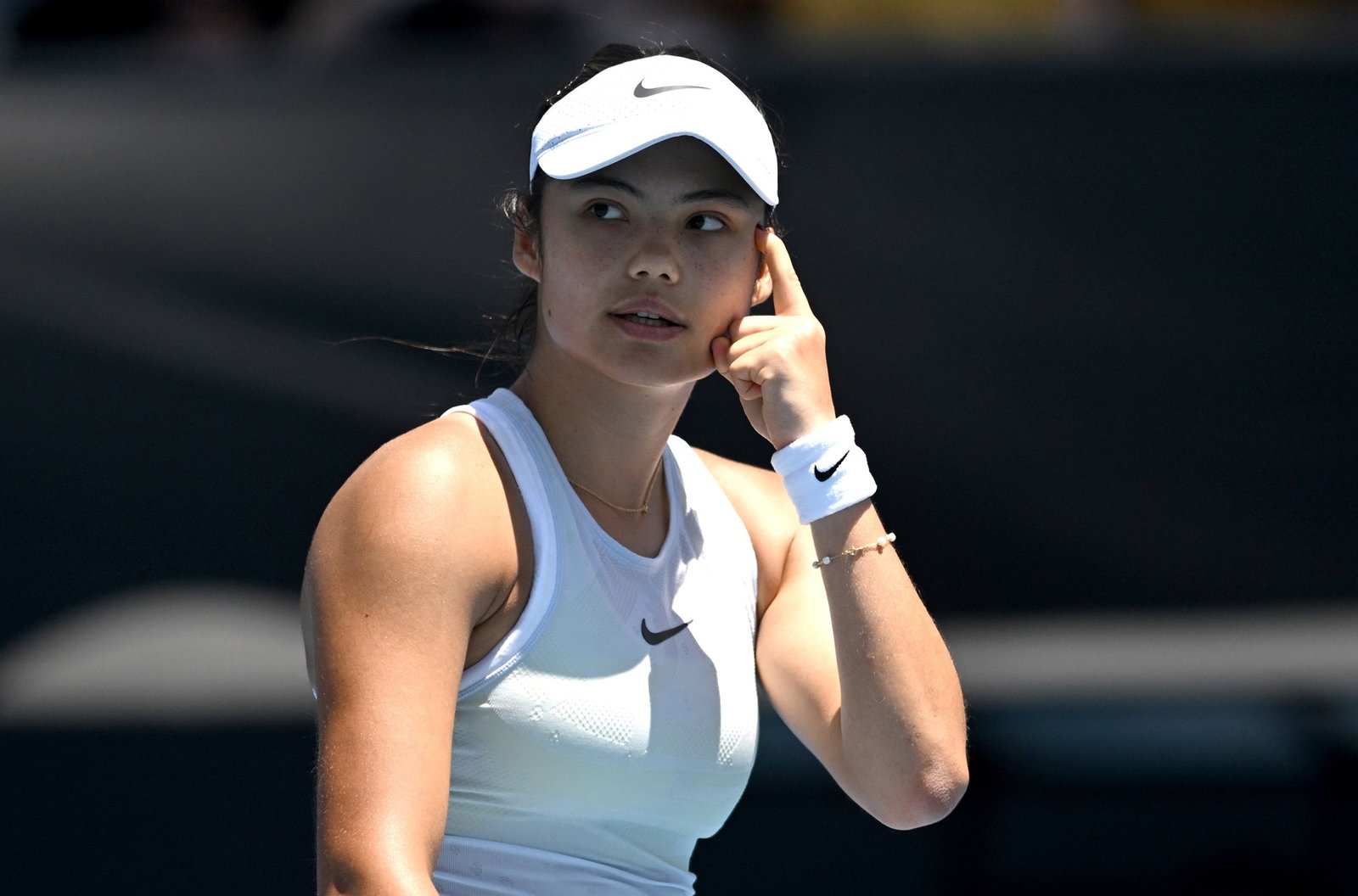 Raducanu puts finger to her temple. 