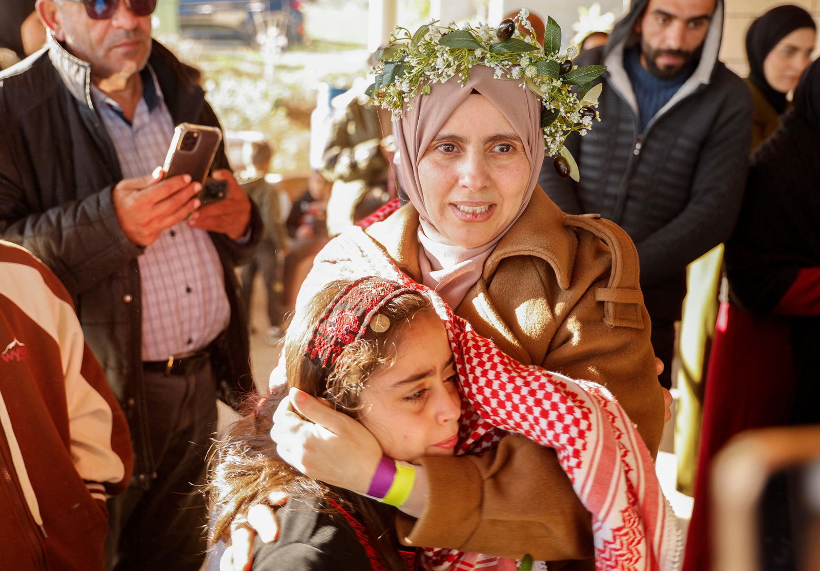 A woman in a floral crown holding a child. 