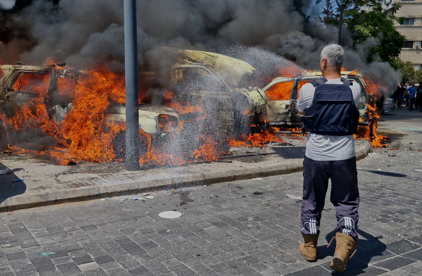 A man extinguishes three cars engulfed in flames.