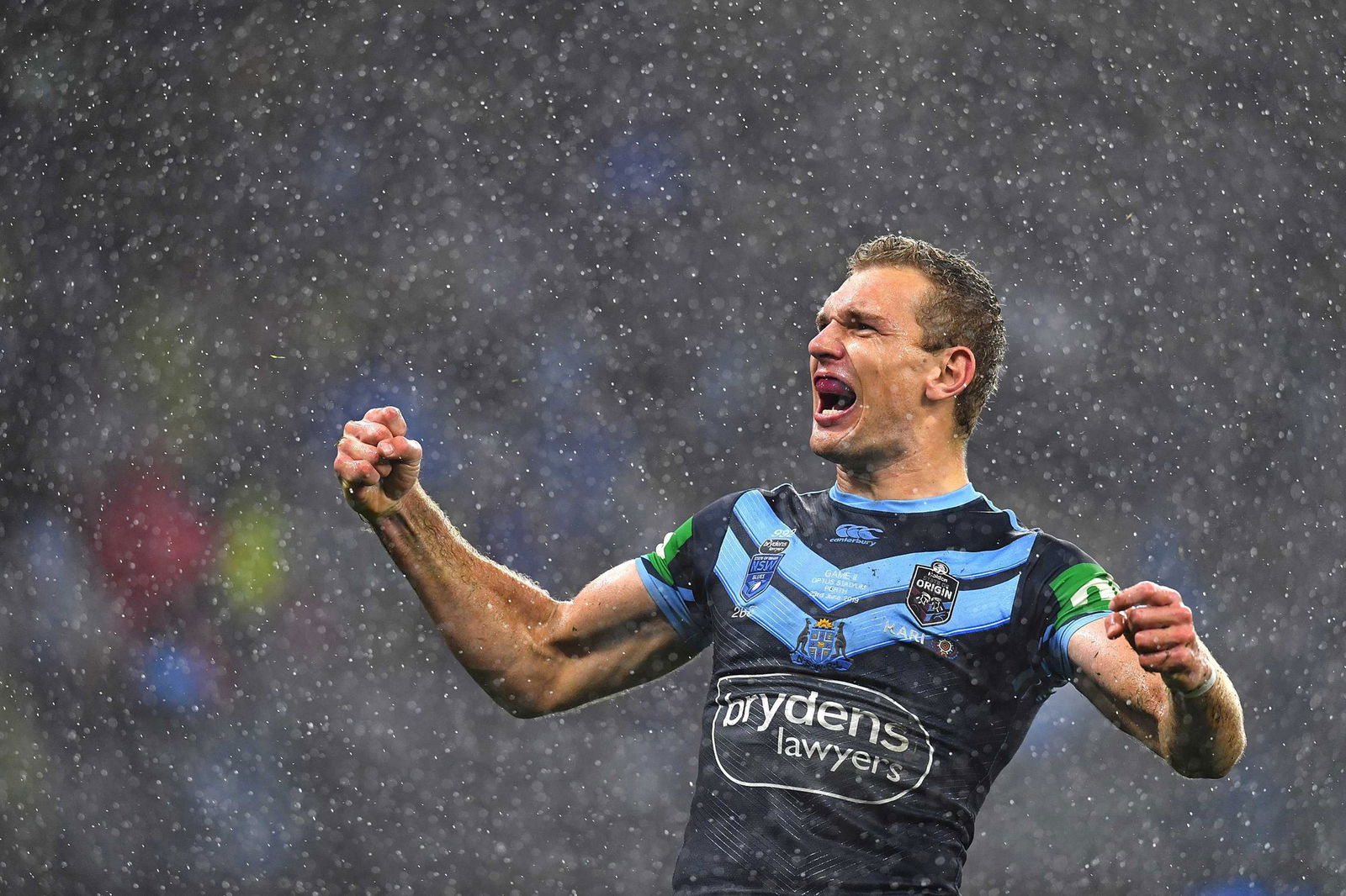 Tom Trbojevic shouts in celebration in the rain during a State of Origin game.