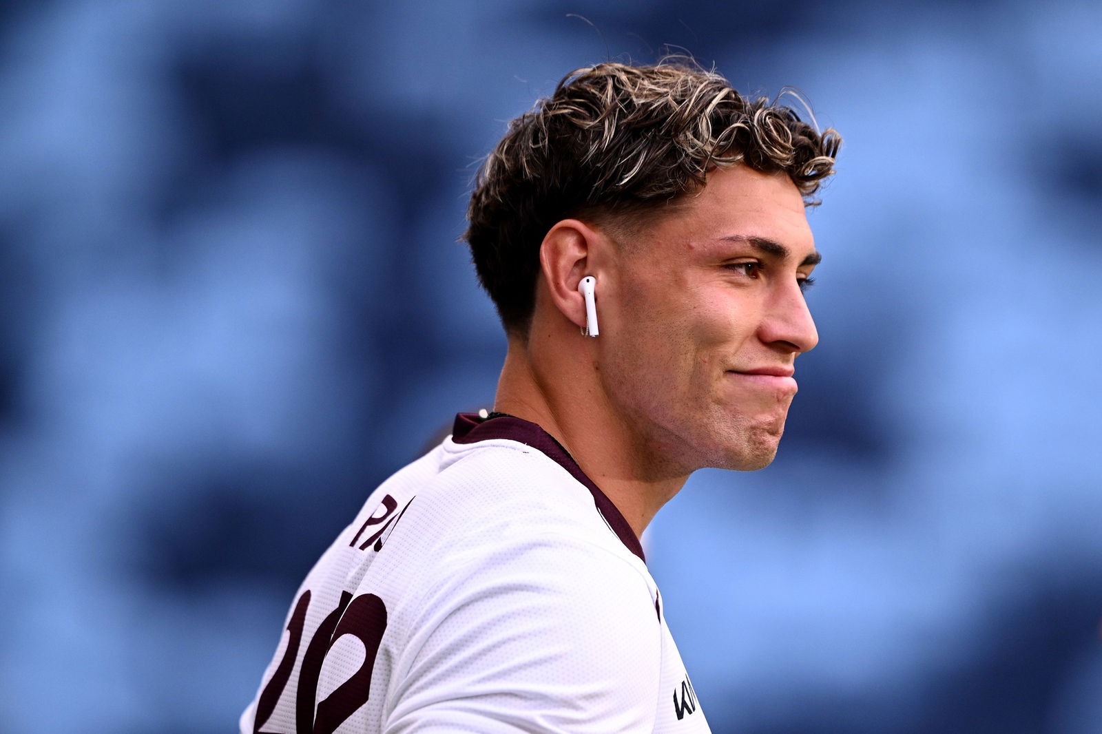 Jordan Riki warm up before Broncos face Roosters, wearing a trainign top, listening to music