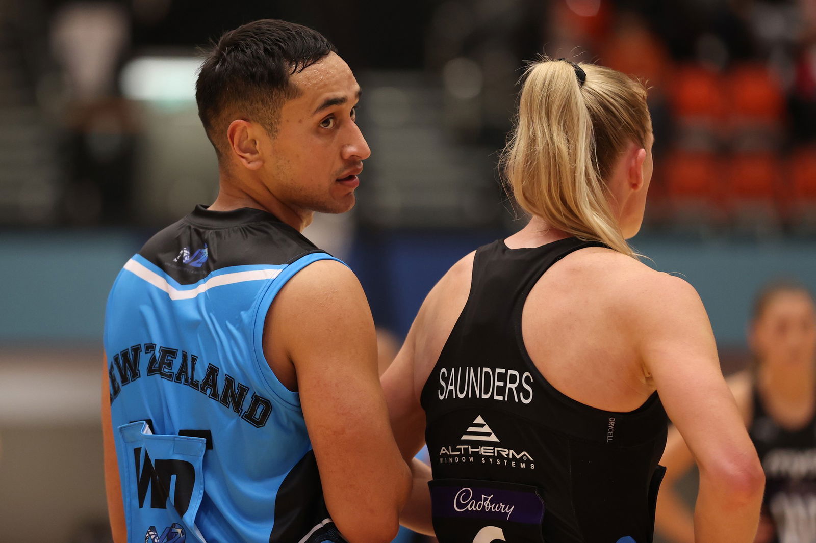 A male player stands alongside a female player