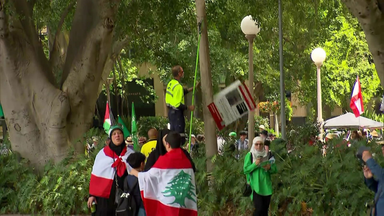 A man taking a sign down in a park