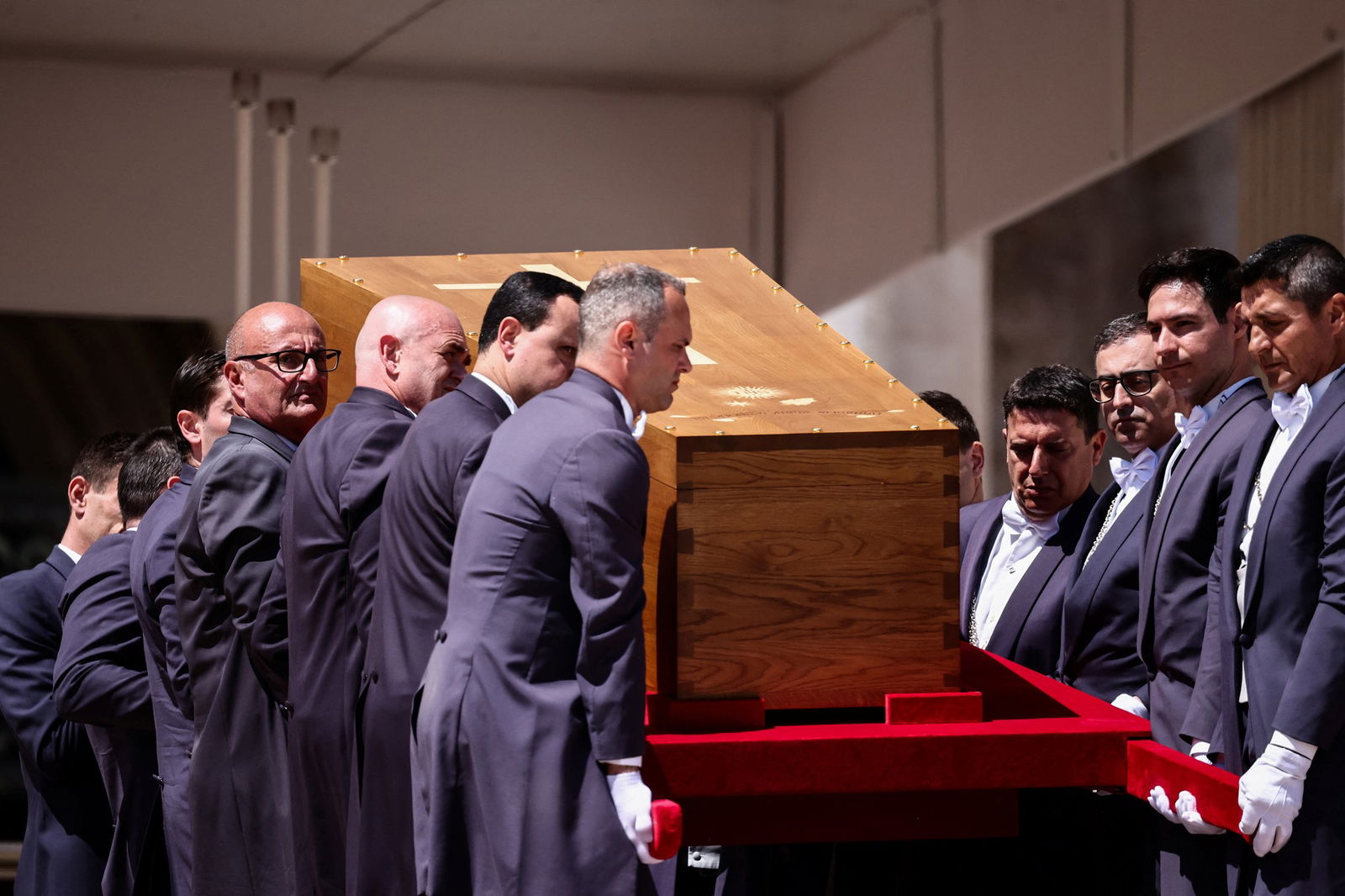 Pallbearers carry a coffin.