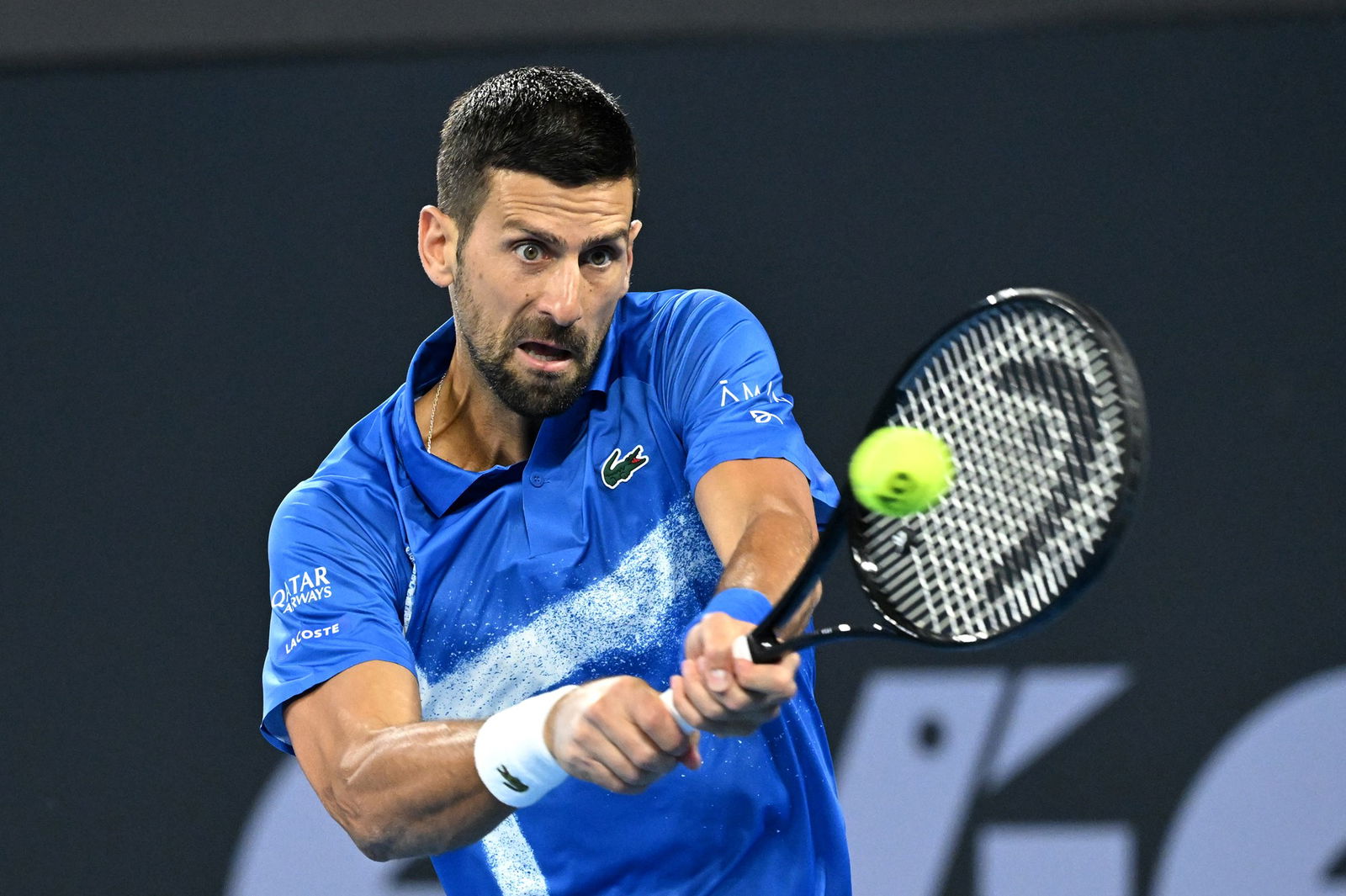 Novak Djokovic plays a backhand.