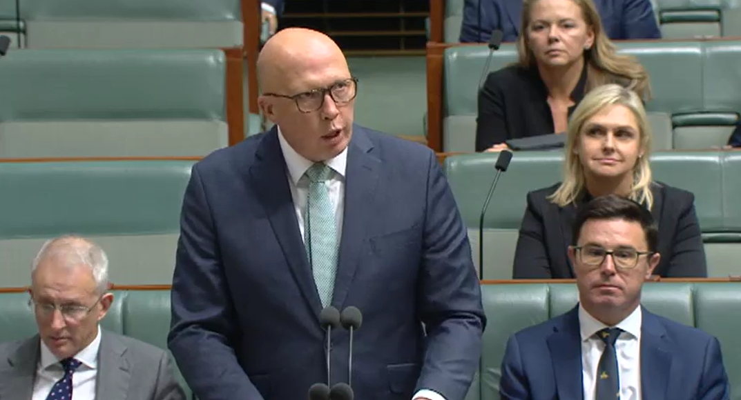A bald middle-aged man speaks in Parliament.