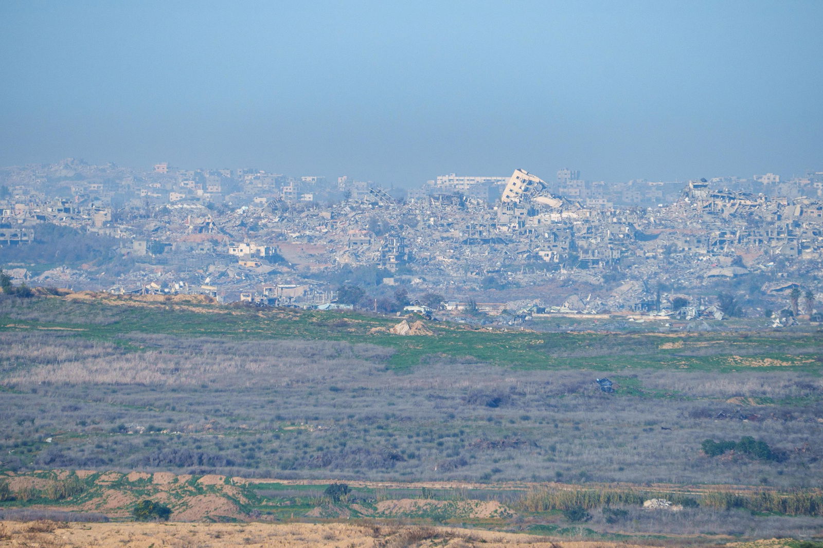 An entire neighbourhood turned to rubble, seen from a distance.