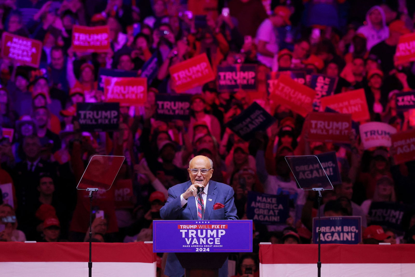 Rudy Giuliani grasps a microphone as he stands at a podium in Madison Square Garden