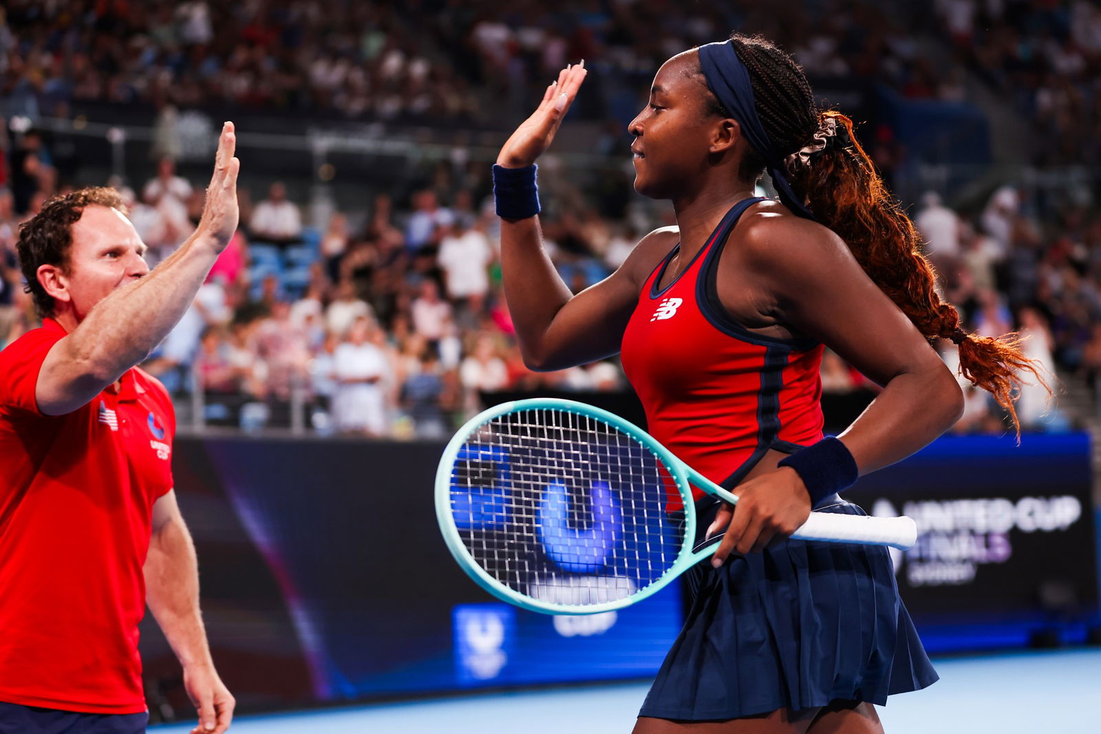 Coco Gauff gives a high five after winning her singles match.