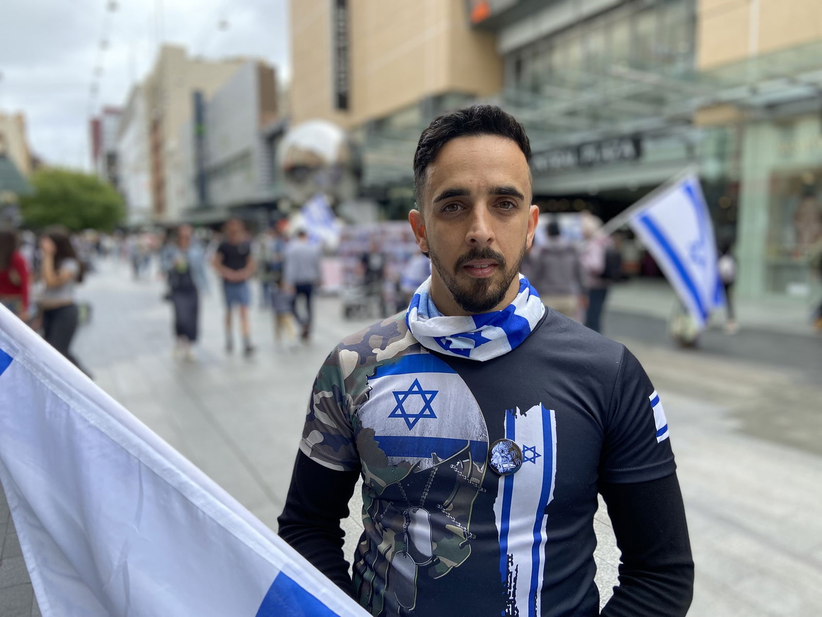 A man draped in Israel flags and colours