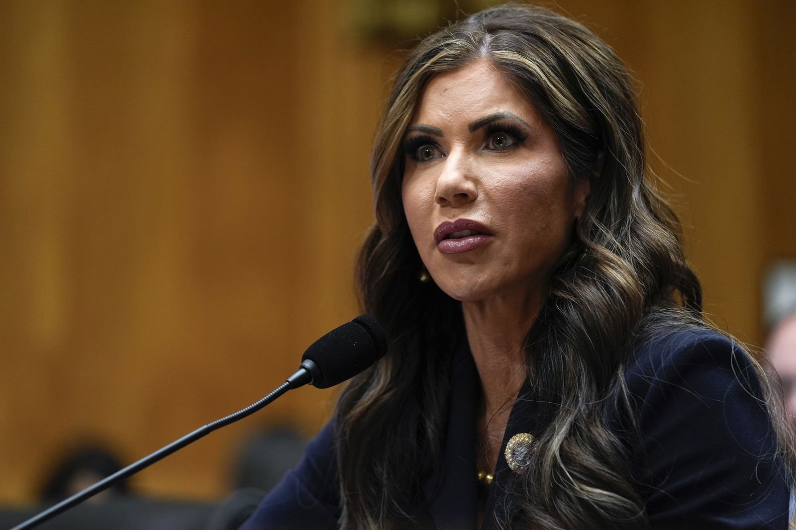 Kristi Noem at a microphone. 