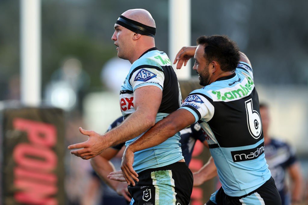 Braydon Trindall hugs Tom Hazelton from behind after a try for the Sharks.