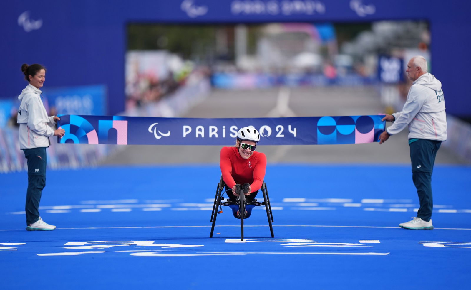 Swiss wheelchair racer Catherine Debrunner smiles after crossing the finish line in the women's marathon T54. 