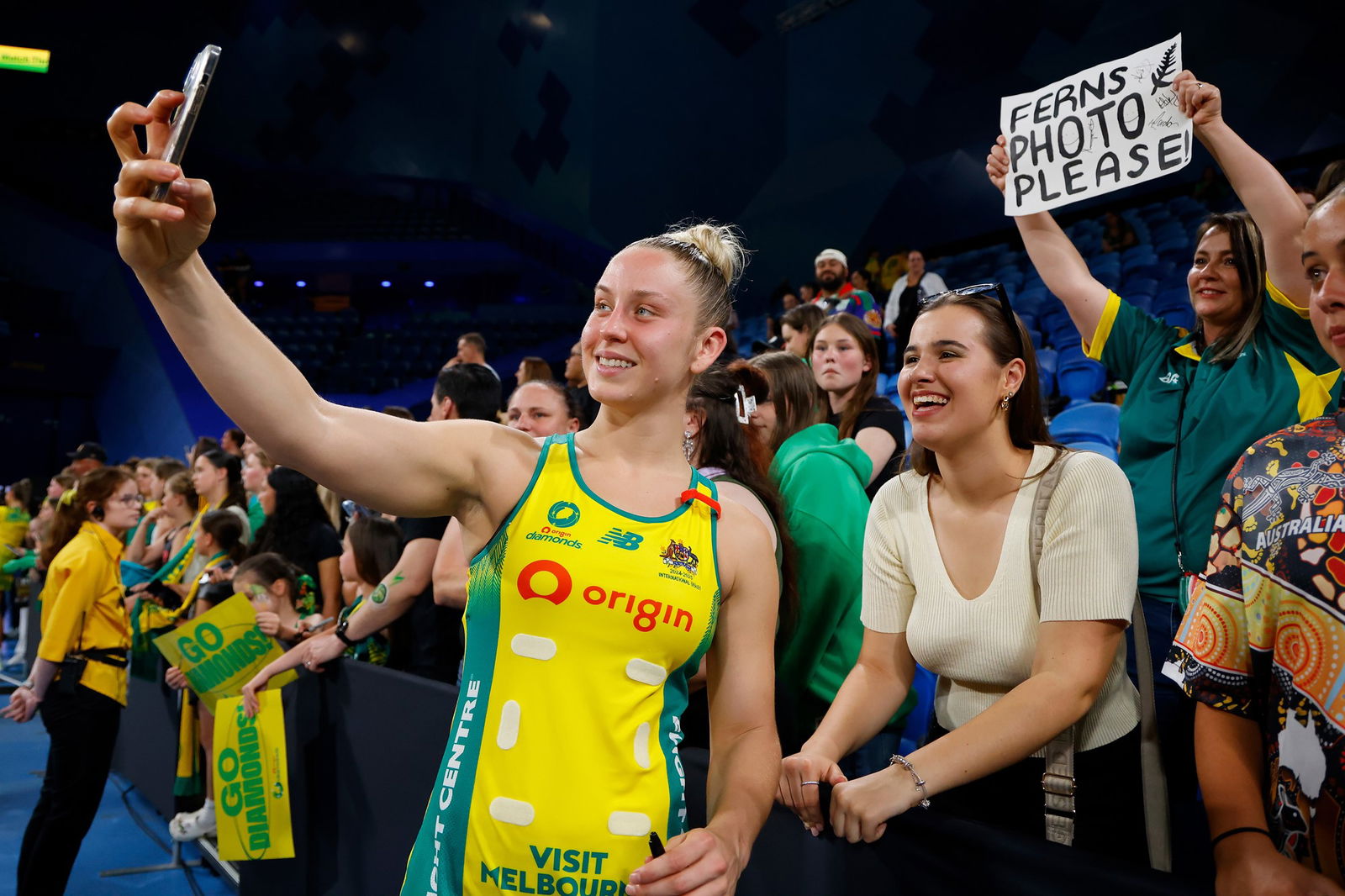 A player takes a selfie with a fan with a forced smile