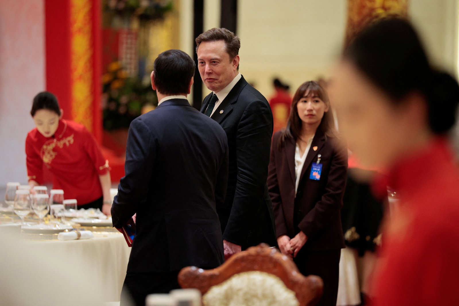 Elon Musk looks at Marco Rubio who is facing the camera
