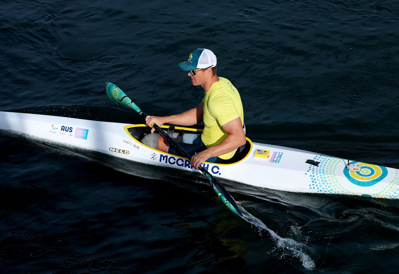 Para canoeist Curtis McGrath sits in his kayak holding his paddle at the end of a race.