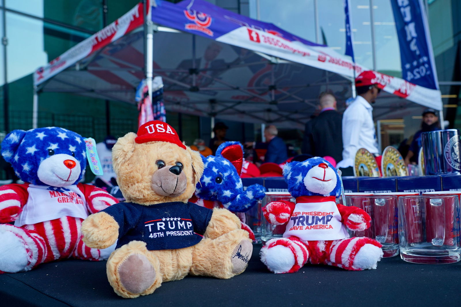 Teddies wearing Trump shirts and USA hats sit on a table