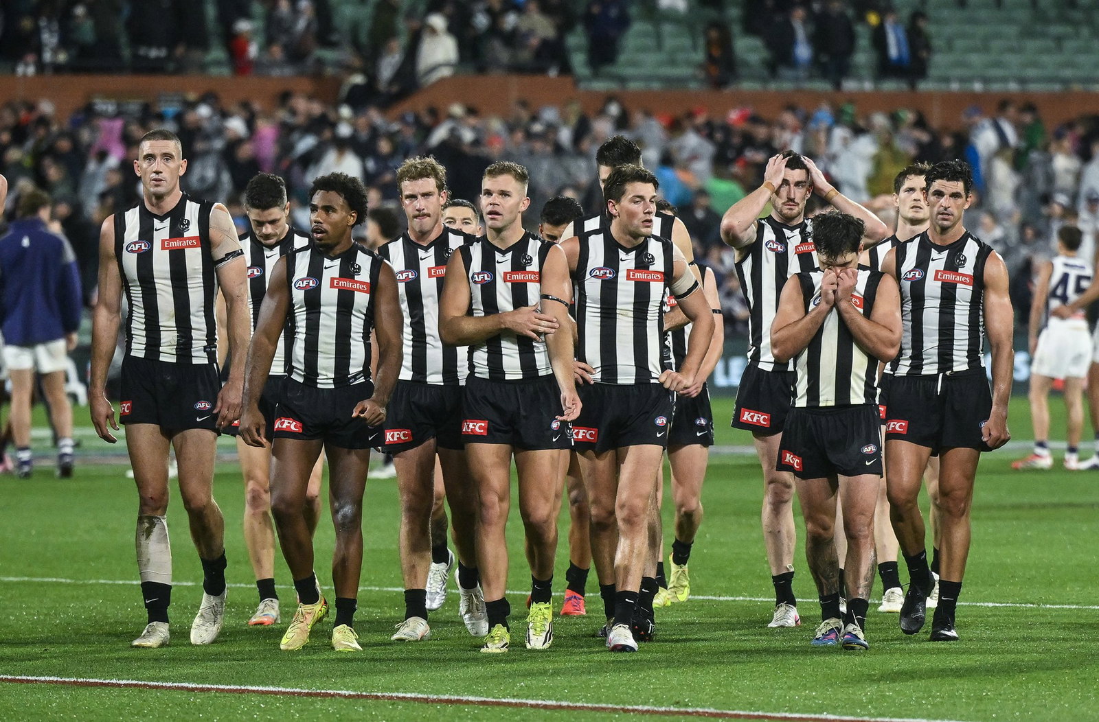 Collingwood players walk from the field after losing to Fremantle.