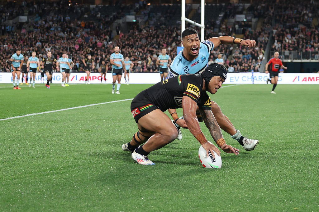 Brian To'o scores a try as Ronaldo Mulitalo of the Sharks tries to stop him.