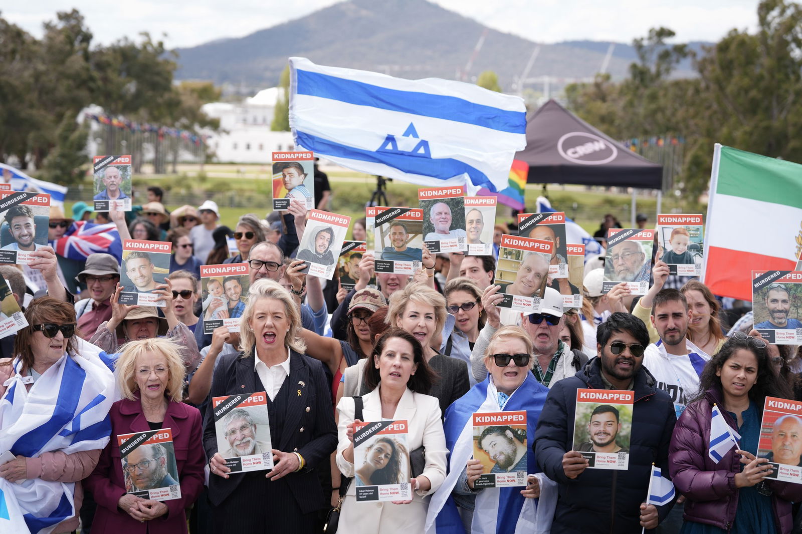 A group of people holding Israel flags and kidnapped posters. 