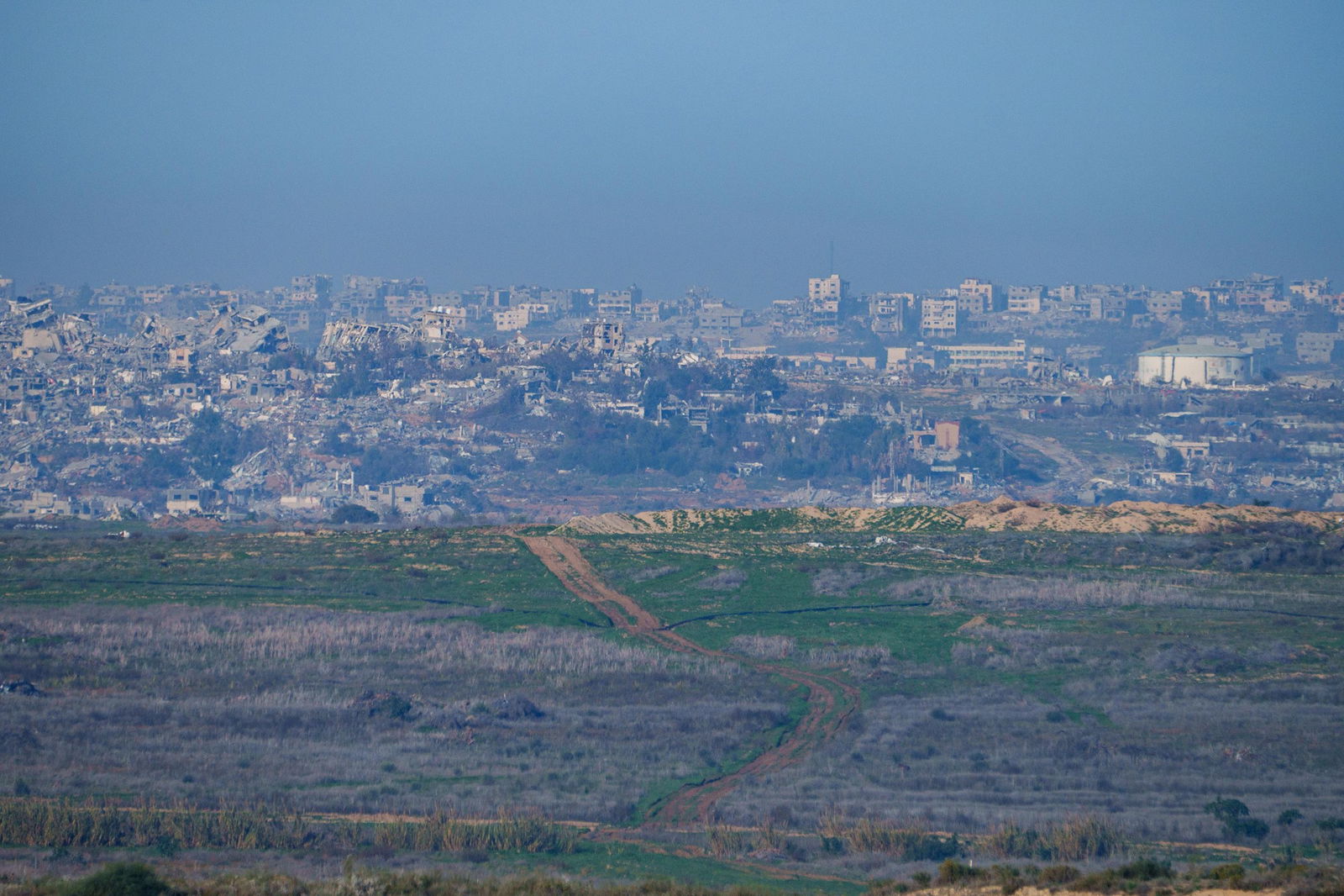 An entire neighbourhood turned to rubble, seen from a distance.