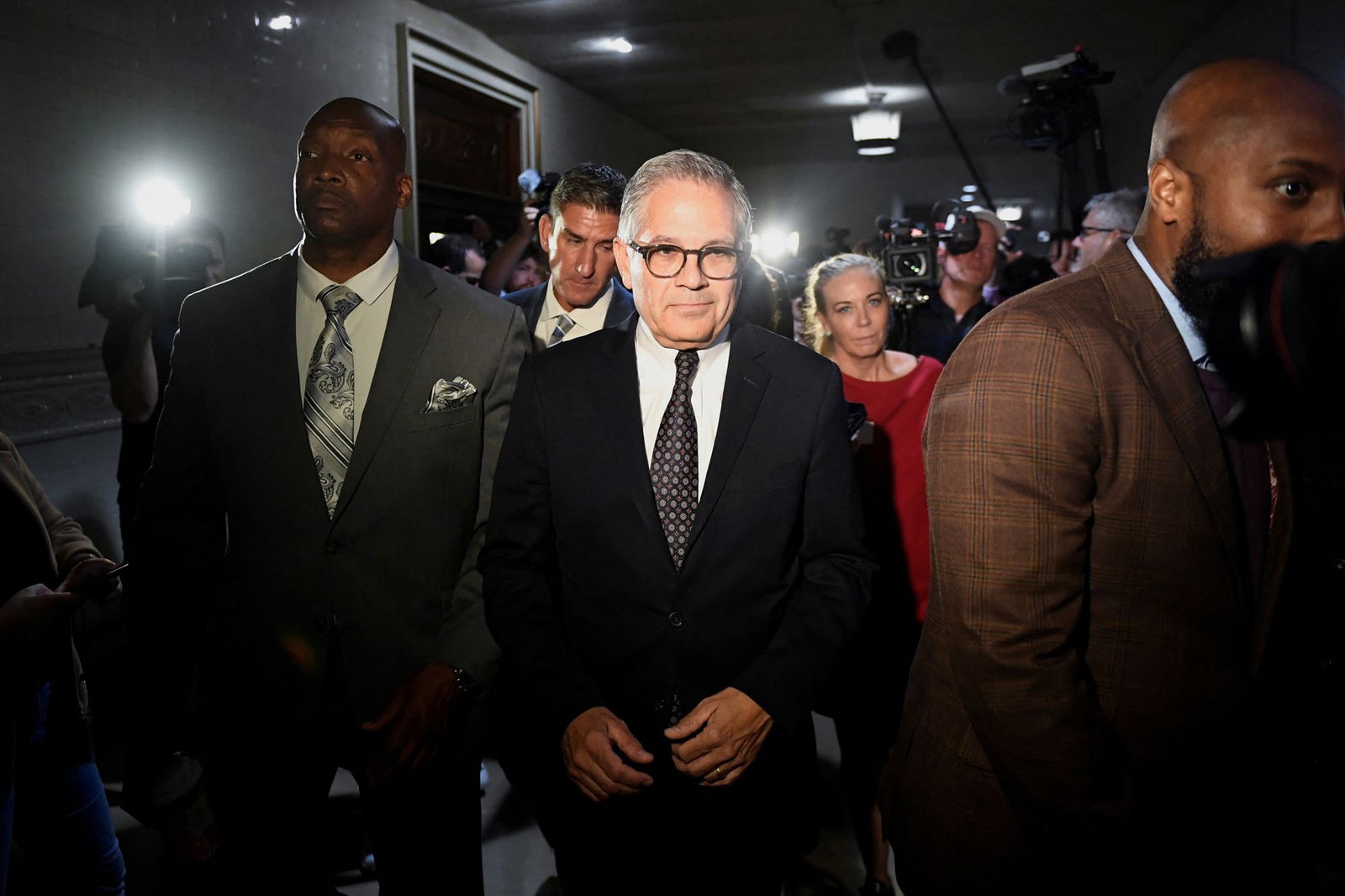 Lawyers walk through a courtroom.