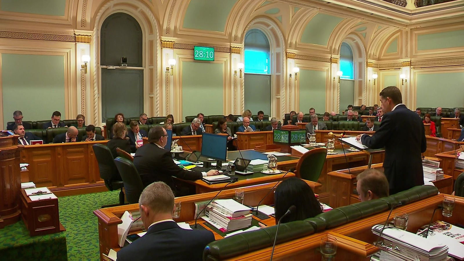 A man in a suit addresses parliament.