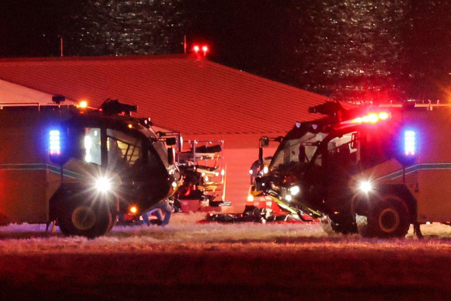 Two trucks side by side with flashing lights