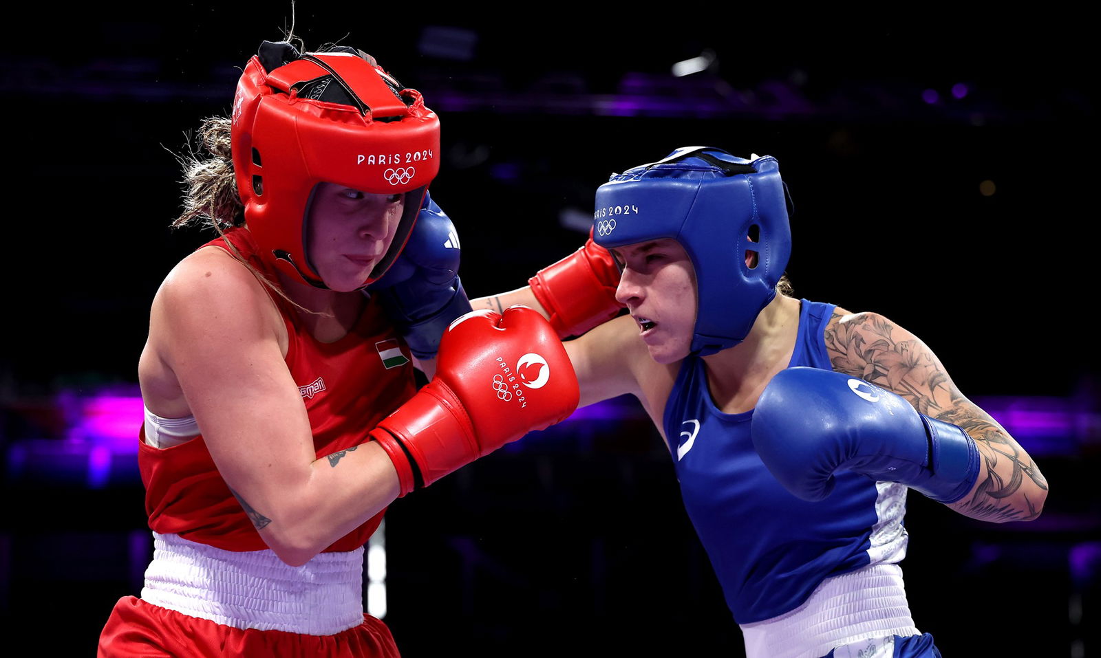 Hungary's Anna Hamori and Australia's Marissa Williamson exchange punches in their women's 66kg bout at the Paris Olympics.