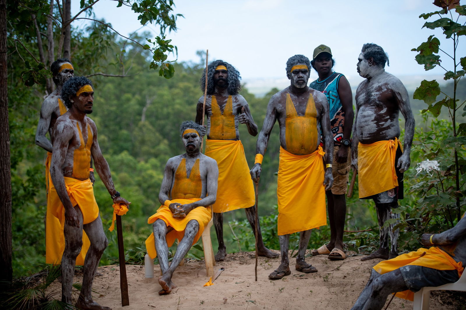 A group of men in yellow and white body paint, standing around.