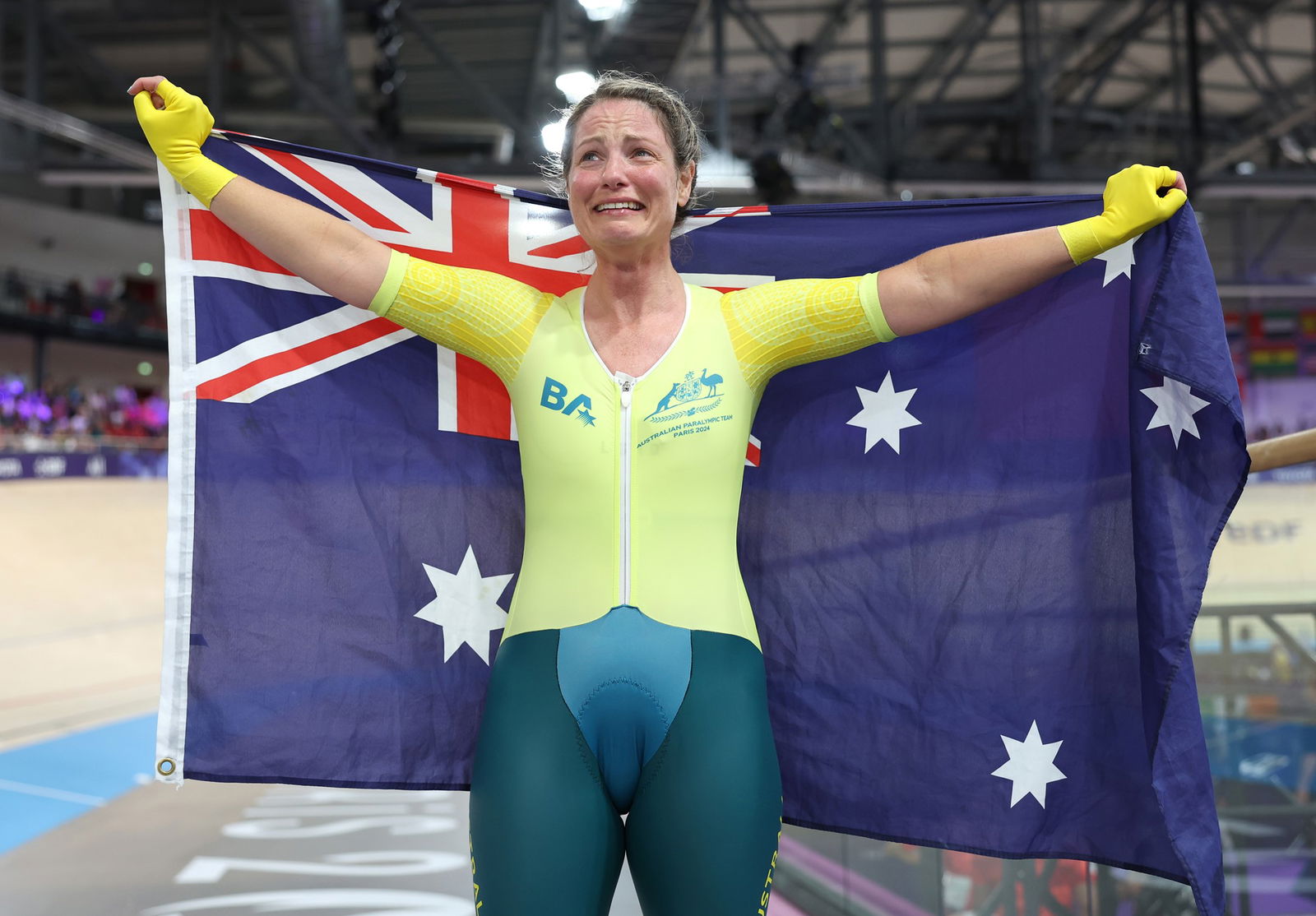 Cyclist Emily Petricola celebrates with the Australian flag after winning the women's C4 3000m individual pursuit in Paris.