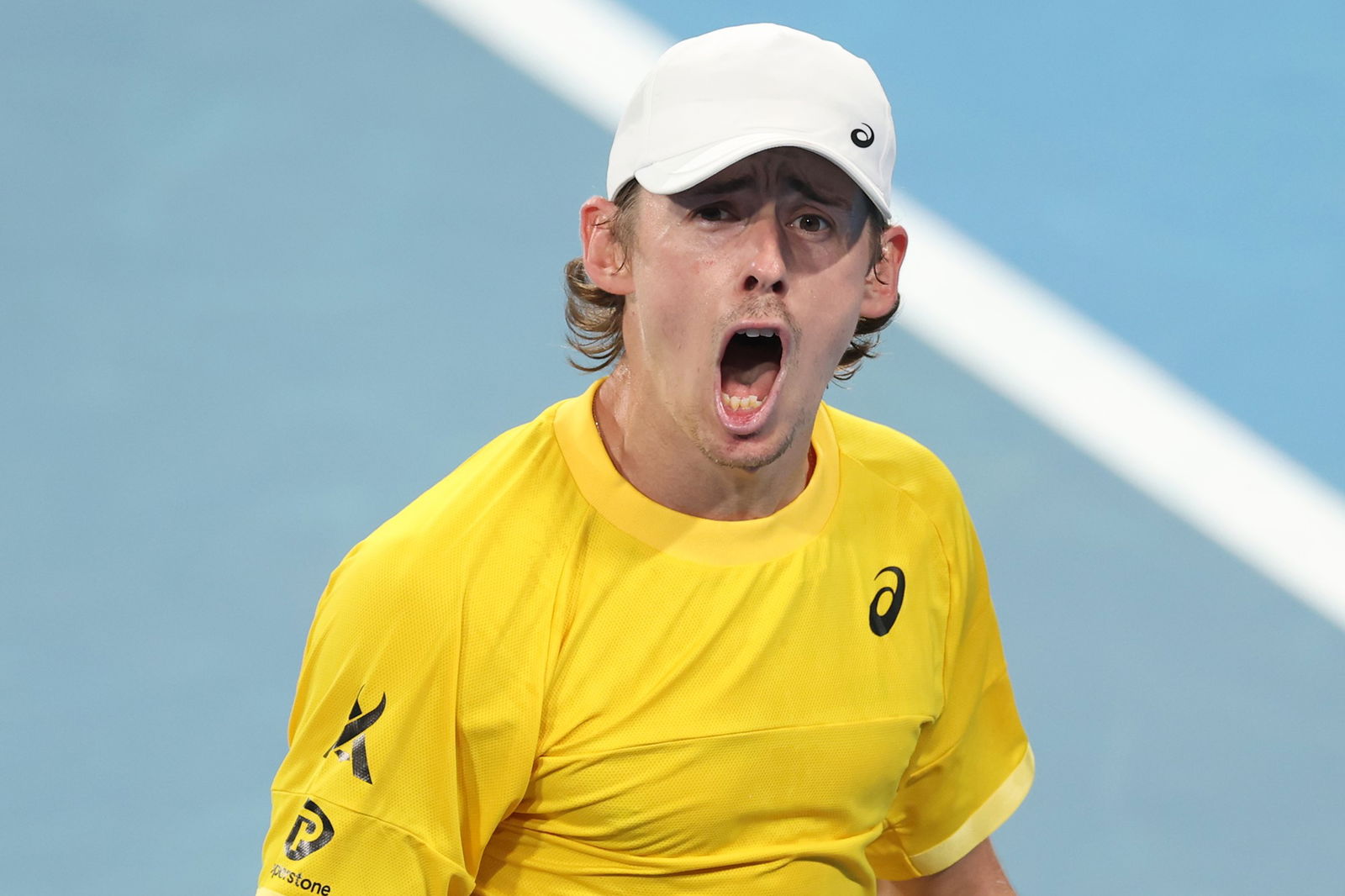 Alex de Minaur screams out as he celebrates winning a point.