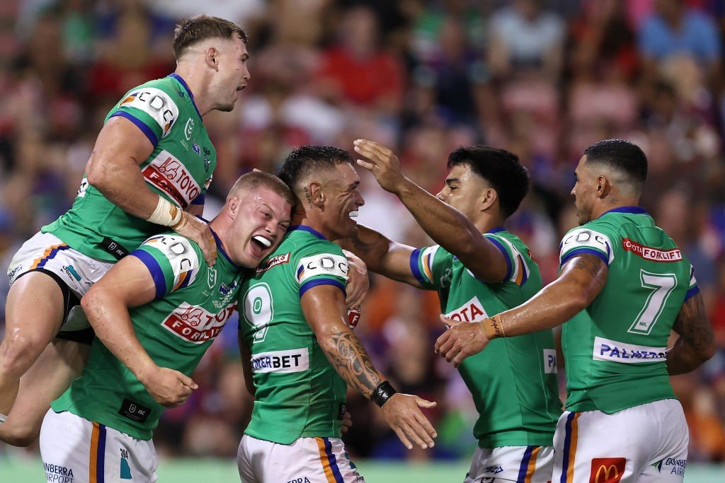 Canberra Raiders players celebrate a try together.