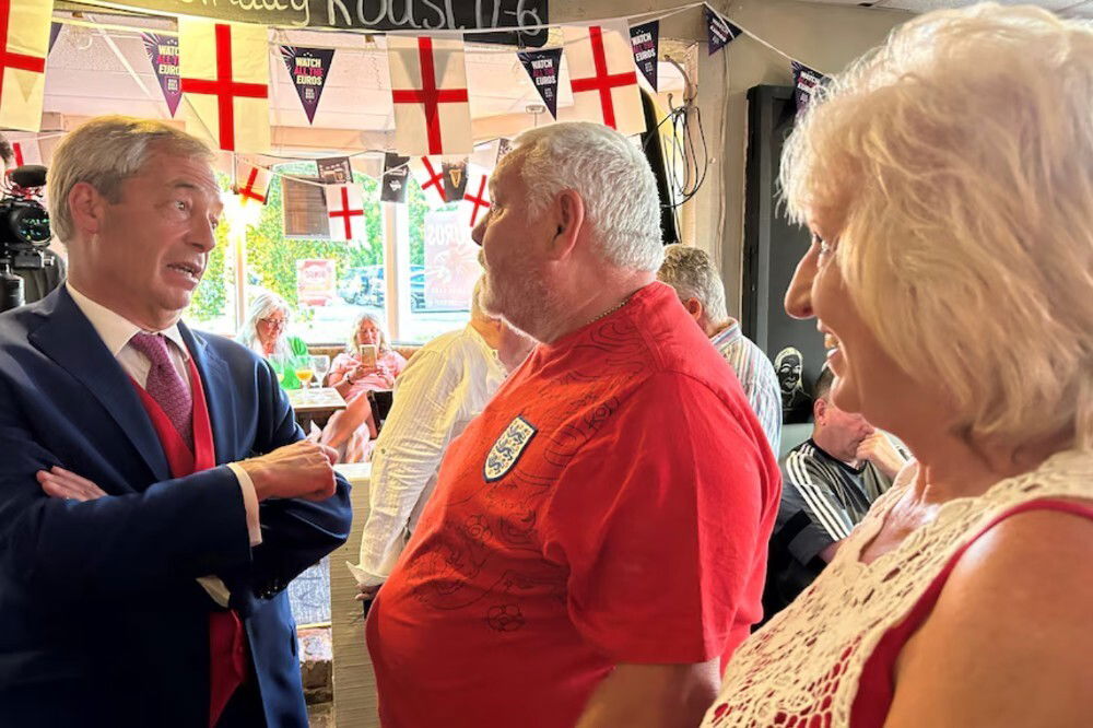 A man speaking to a man and a woman.