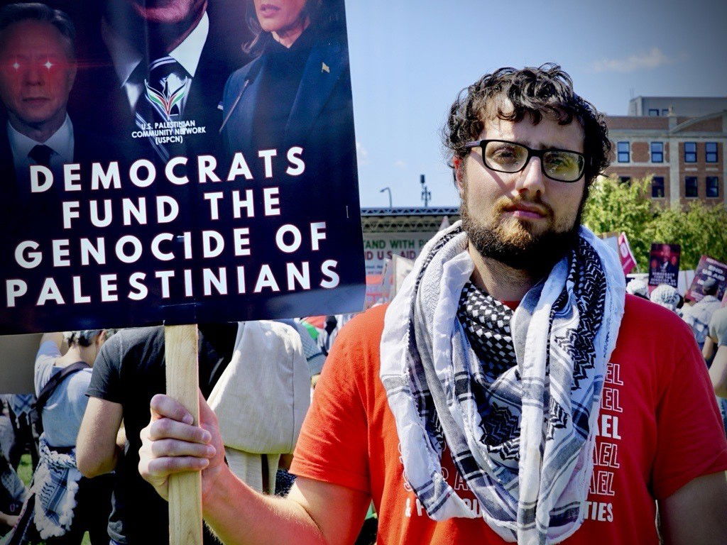 A demonstrator holds up a sign that says Democrats fund the genocide of Palestinians