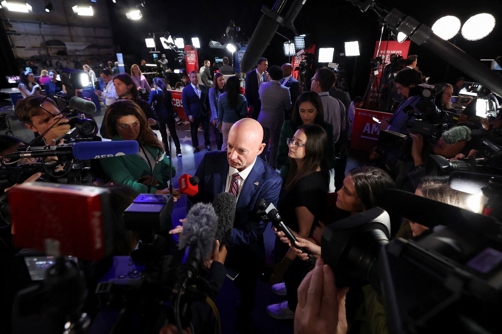 Mark Kelly is inundated by journalists holding microphones and cameras