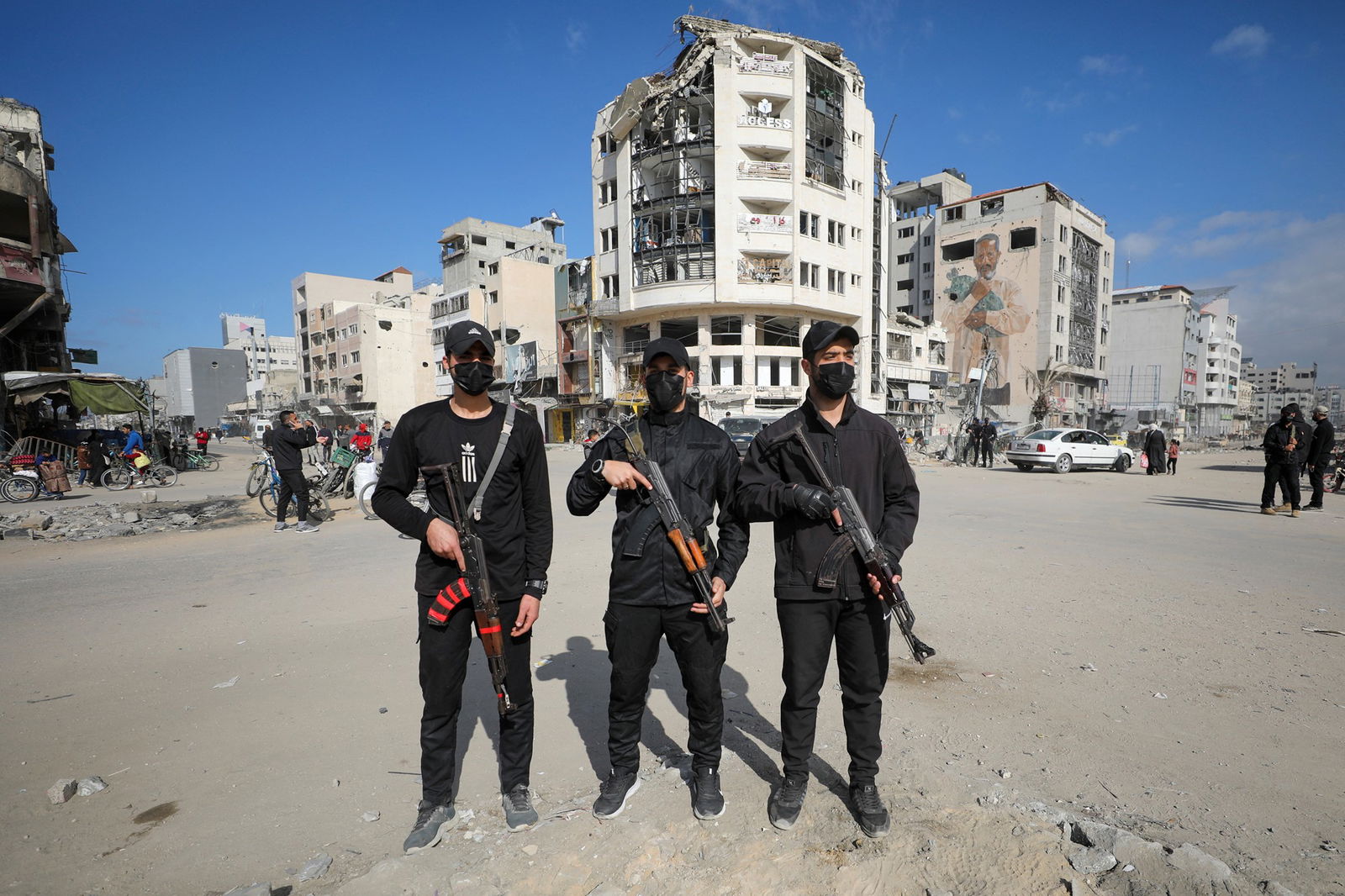 Three men dressed in black holding guns. 